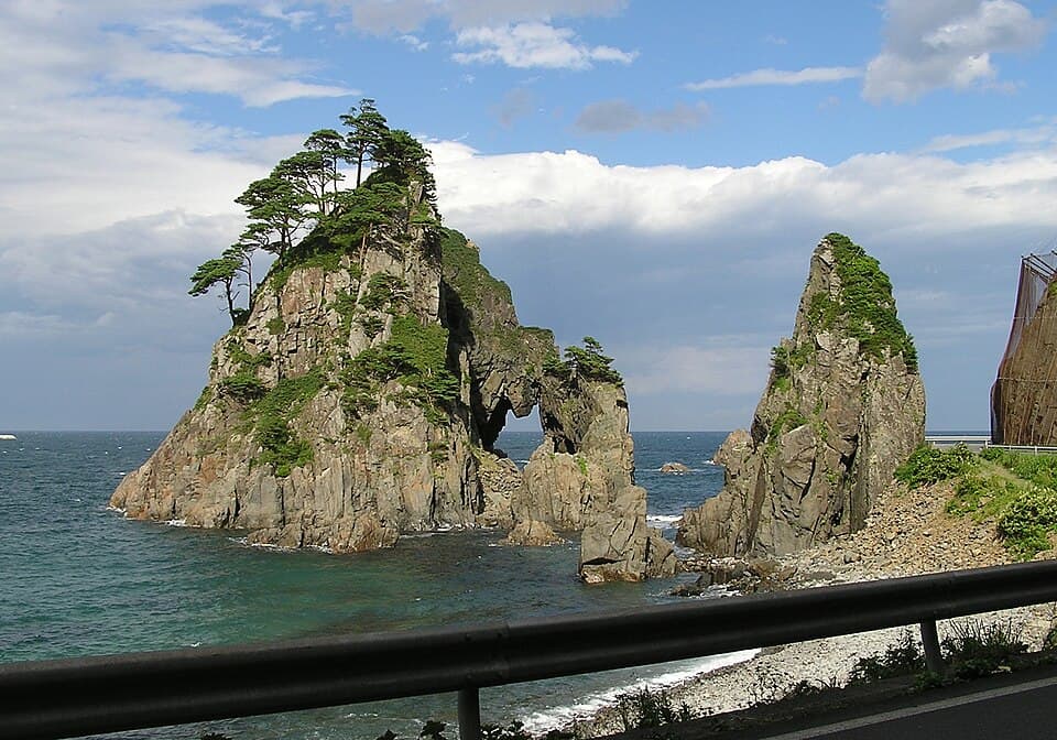 断崖にぽっかり穴があいた小袖海岸のシンボル奇岩で記念撮影